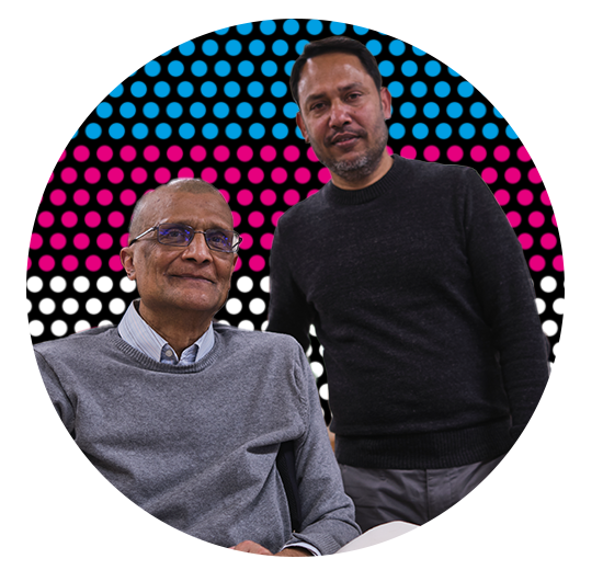 an older male wheelchair user with a young man standing behind him