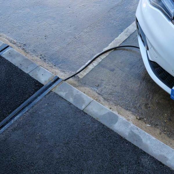 channel in the pavement with an electric vehicle charging cable running through it