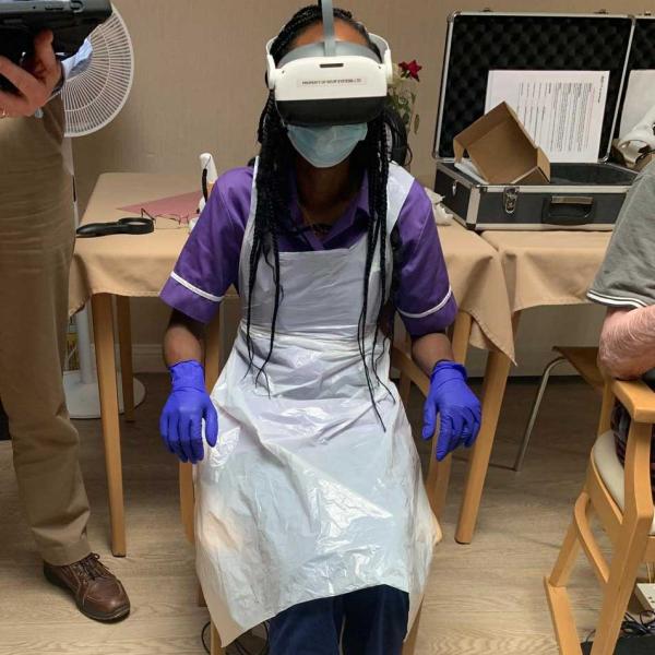 female nurse sitting in a chair wearing a VR headset