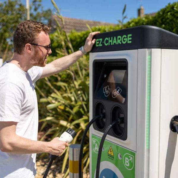 man reading the screen on an electric car charging point