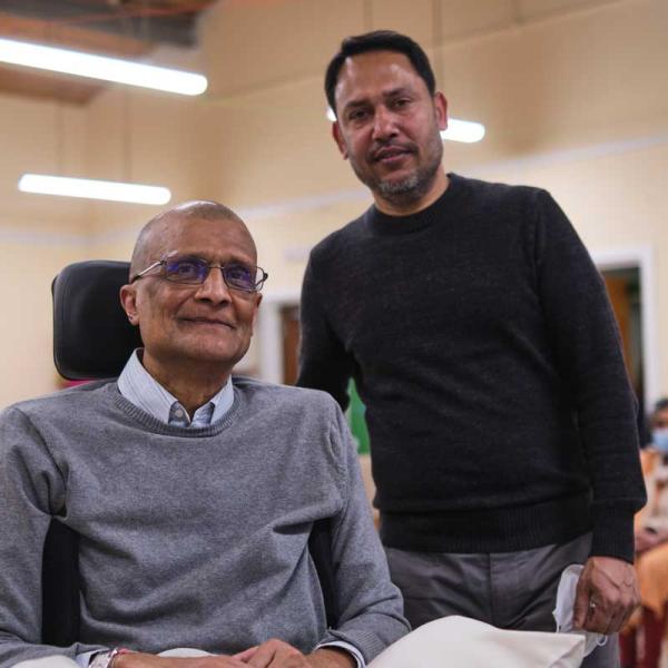 photo of an older man in a wheelchair with a younger man standing behind him